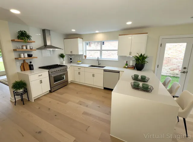 a large white kitchen with granite countertop a large window and a sink