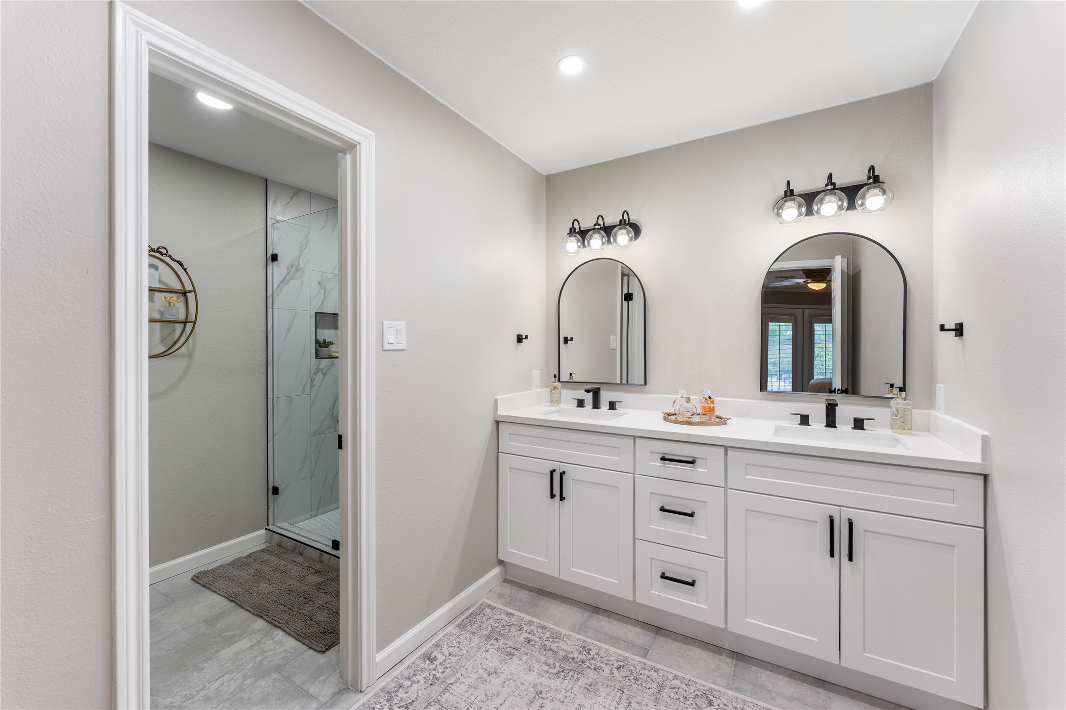 3301 Winter Lane Baytown, TX 77521 - Photo 15 of 28 This bathroom features a modern double vanity with black fixtures, dual mirrors, and ample storage, quartz countertops.