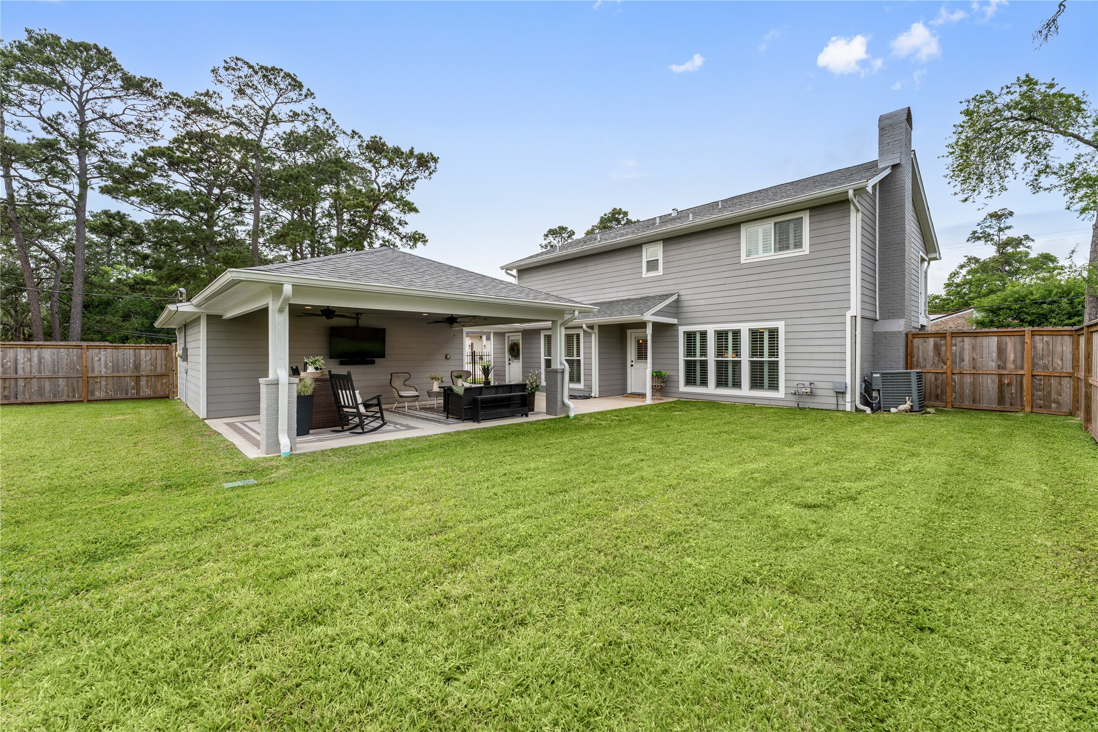 3301 Winter Lane Baytown, TX 77521 - Photo 25 of 28 Spacious backyard featuring a well-maintained lawn, a covered patio with outdoor seating. Wooden fence offers privacy and a serene setting.