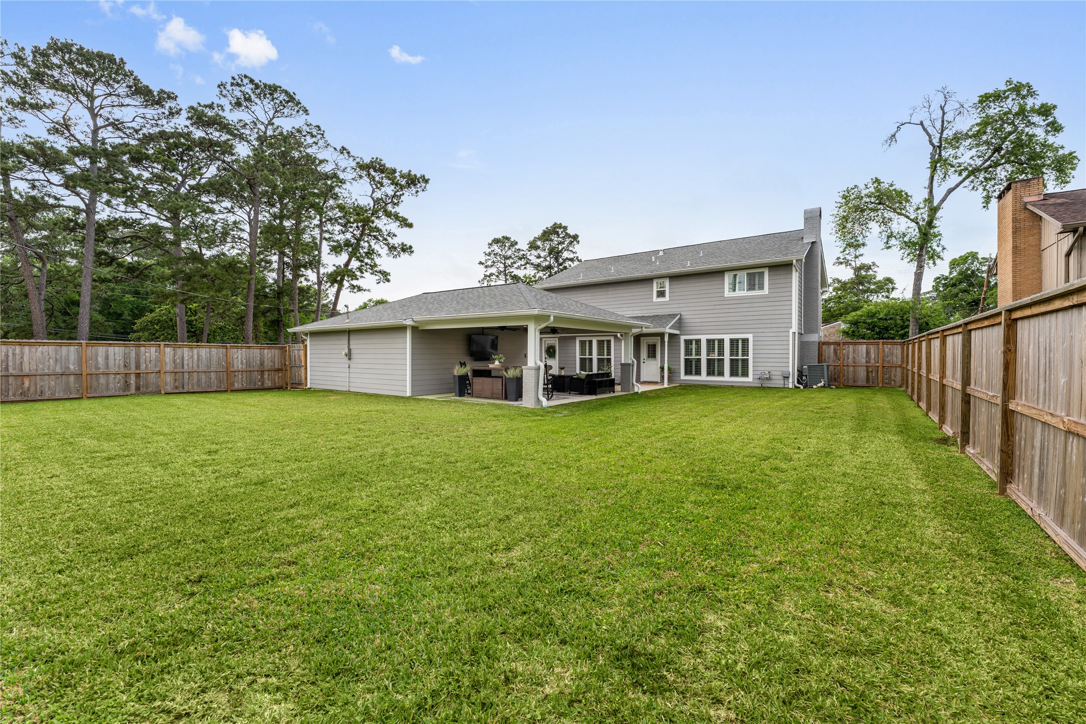 3301 Winter Lane Baytown, TX 77521 - Photo 26 of 28 Spacious backyard featuring a well-maintained lawn, a covered patio with outdoor seating. Wooden fence offers privacy and a serene setting.