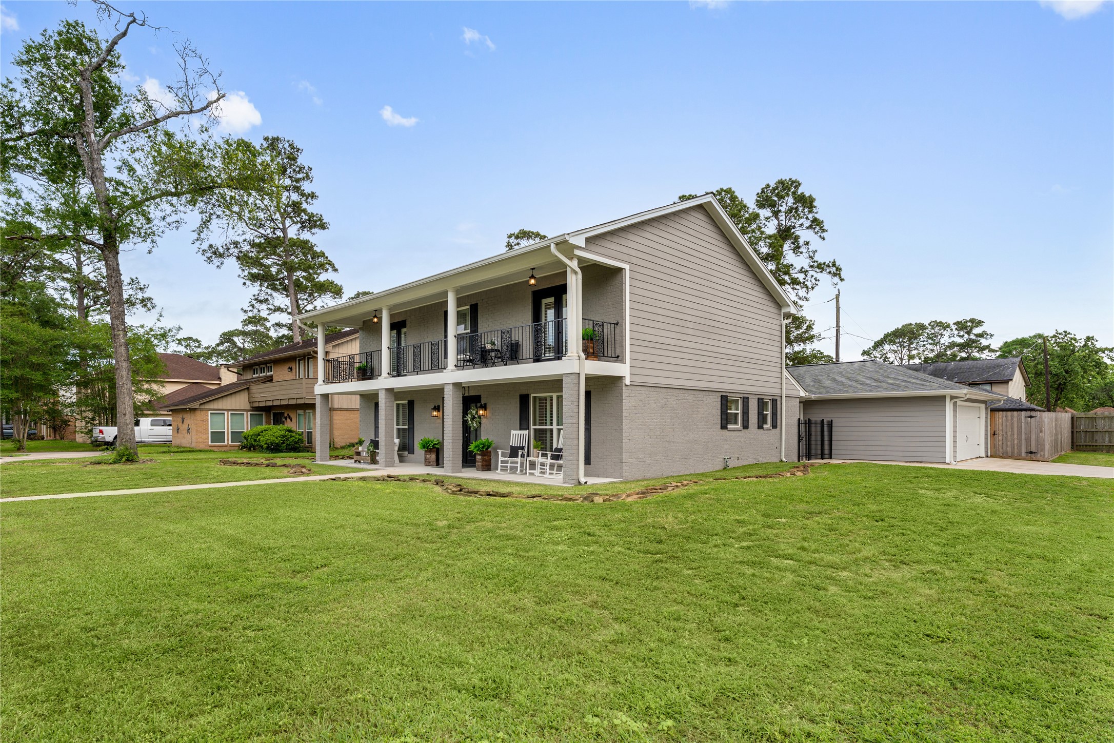 3301 Winter Lane Baytown, TX 77521 - Photo 3 of 28 Corner lot showcasing a charming two-story home with a welcoming front porch, balcony, and graceful tall columns that add timeless Southern elegance to its curb appeal. The well-maintained lawn enhances the home’s warm, inviting presence, and it is ideally situated near walking trails and neighborhood parks.