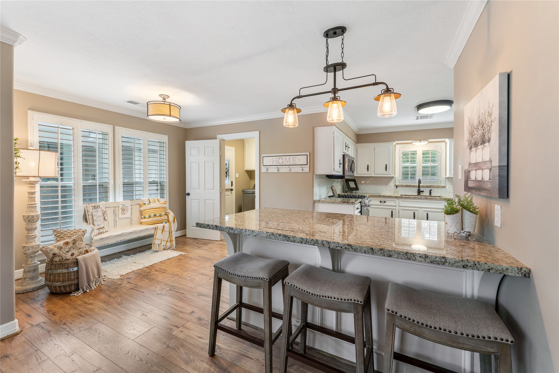 3301 Winter Lane Baytown, TX 77521 - Photo 8 of 28 Kitchen bar with granite countertops and stylish pendant lighting. It opens to a bright seating area/breakfast area with large windows creating a warm, welcoming atmosphere.