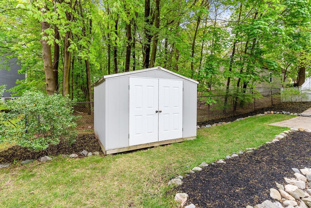 571 Washington Street Winchester, MA 01890 - Photo 30 of 35 a backyard of a house with plants and large trees
