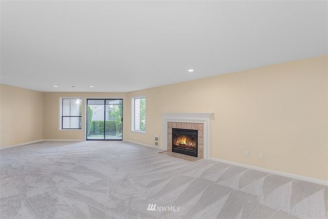a view of an empty room with a fireplace and a window
