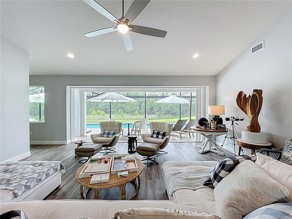 10220 Bay Lake Road Groveland, FL 34736 - Photo 16 of 67 a living room with furniture gym equipment and a large window