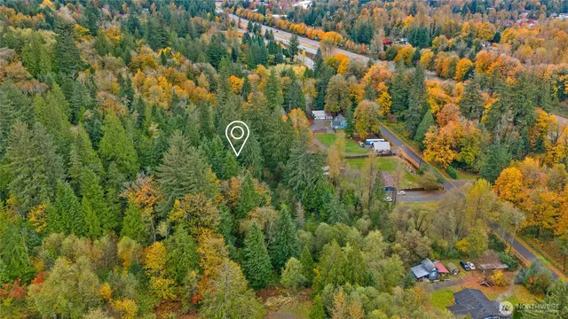 an aerial view of residential houses with outdoor space and trees