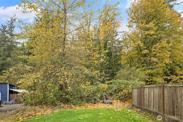 a view of a yard with wooden fence