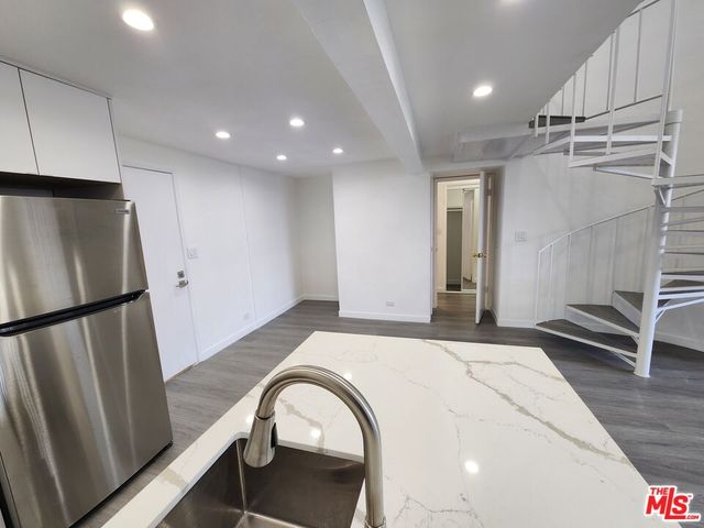 a room with wooden floors and kitchen view