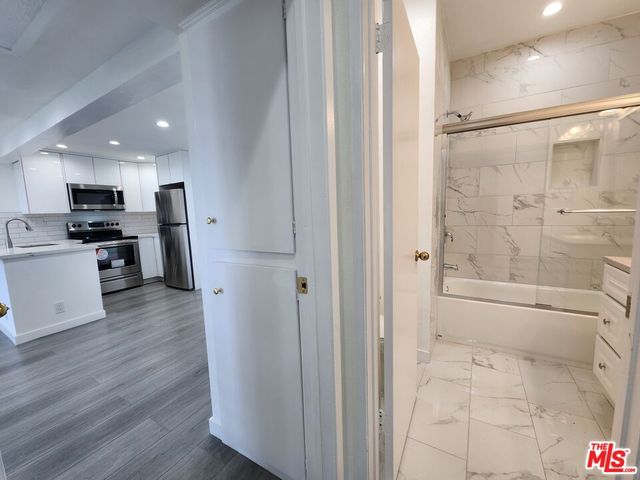 a bathroom with a bathtub shower sink and toilet