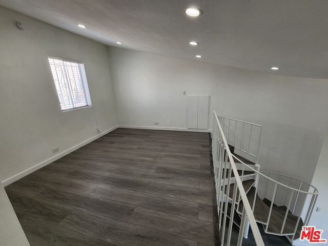 a view of a tennis ground with large trees