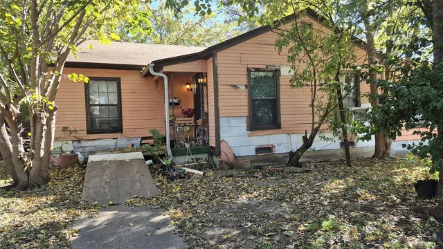 a view of a house with a yard and tree s