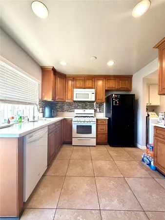 a kitchen with granite countertop a refrigerator and a sink