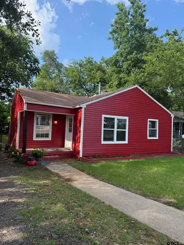 a view of a yard in front of a house with large tree