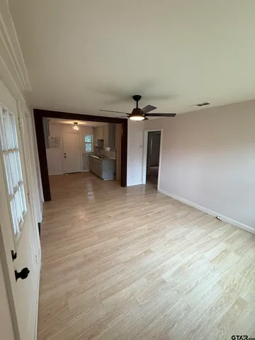 an empty room with wooden floor and entrance
