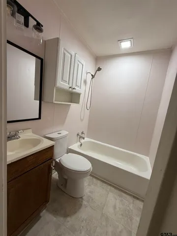 a bathroom with a sink a toilet a mirror and bathtub