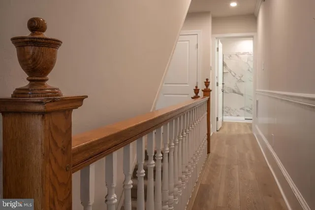 a view of a hallway with wooden floor and staircase