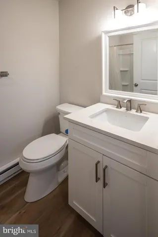 a bathroom with a toilet a sink and mirror