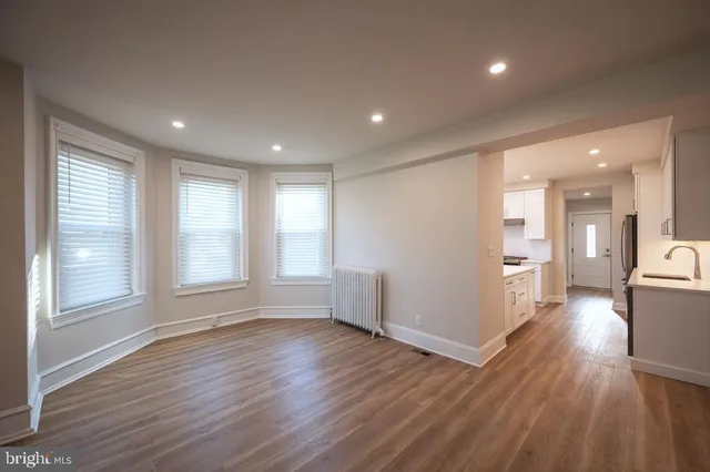 a view of empty room with wooden floor and windows