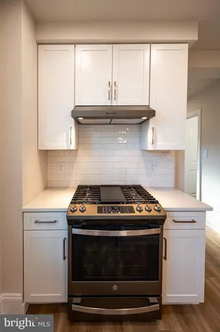 a stove top oven sitting inside of a kitchen