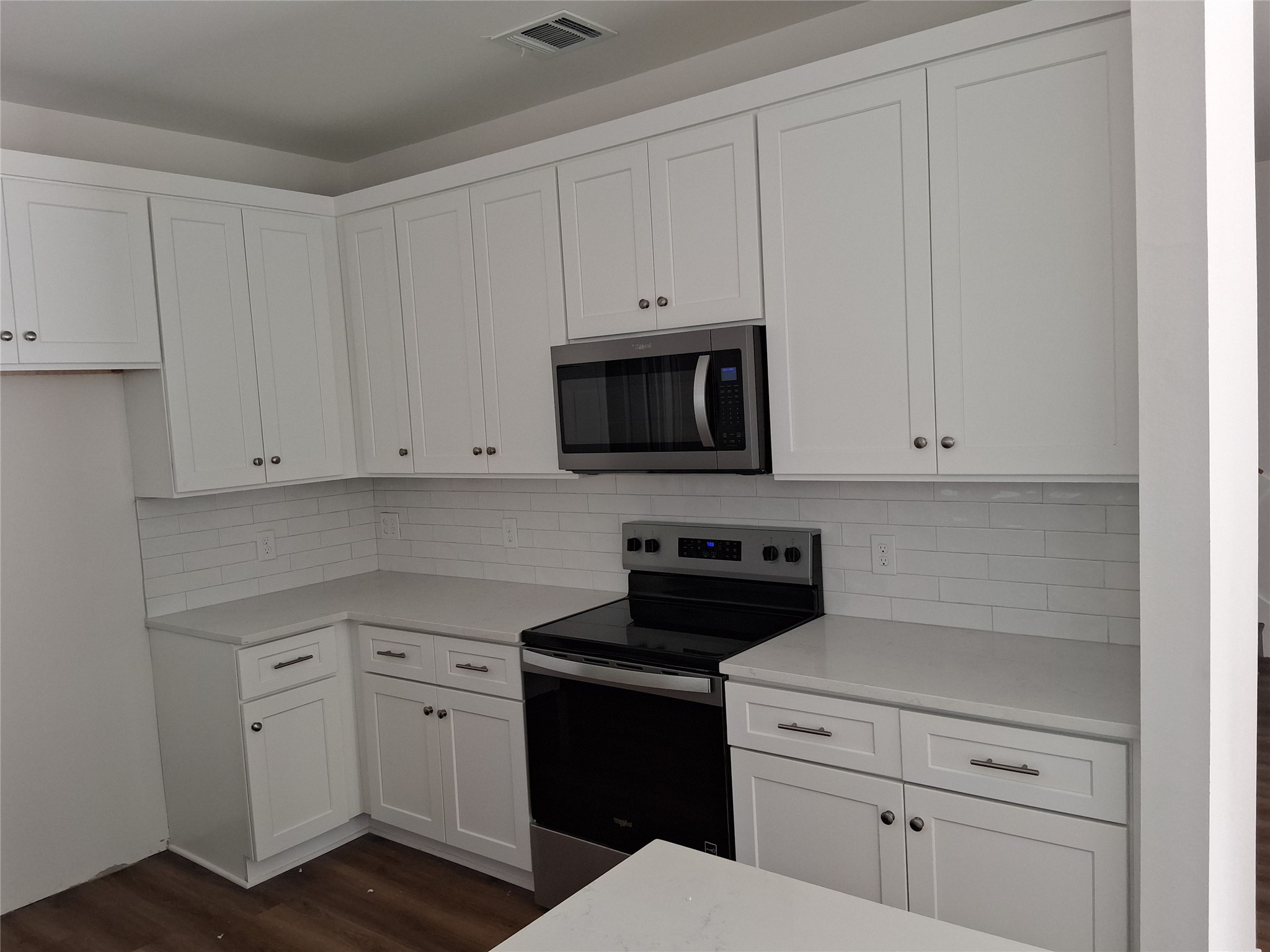6835 Landor Street Houston, TX 77028 - Photo 6 of 32 a kitchen with white cabinets and black appliances