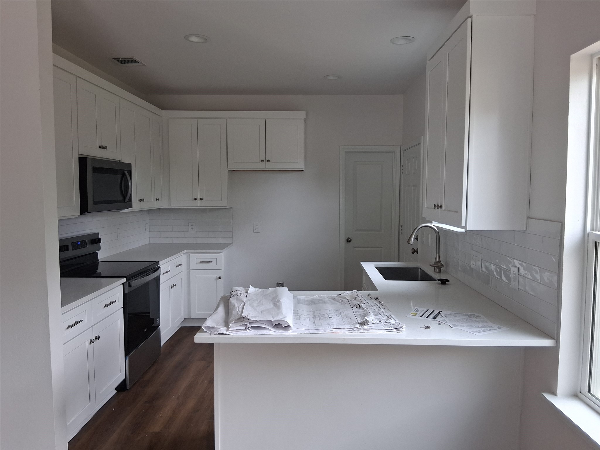 6835 Landor Street Houston, TX 77028 - Photo 9 of 32 a kitchen with stainless steel appliances white cabinets a sink and a stove