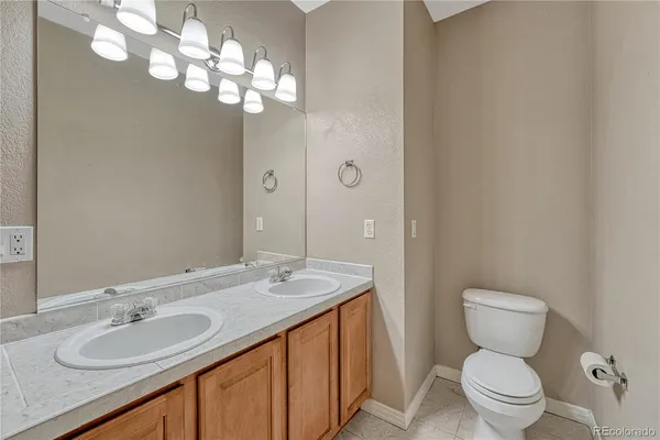 a bathroom with a granite countertop toilet sink and mirror