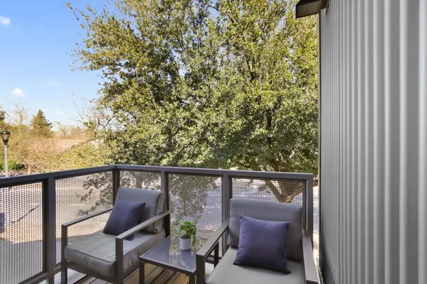 a view of roof deck with chair and wooden fence