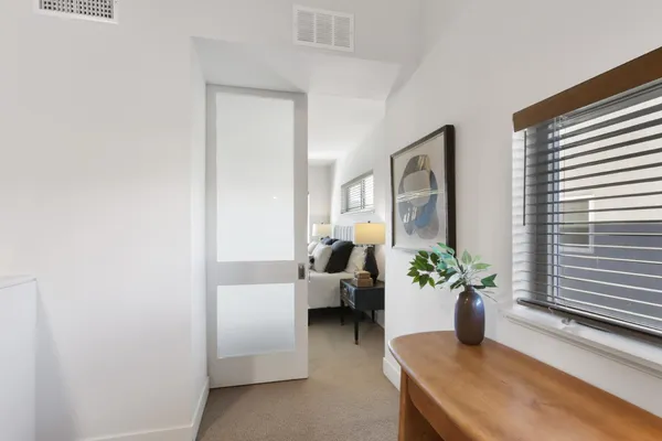 a bedroom with a bed and painting on the wall