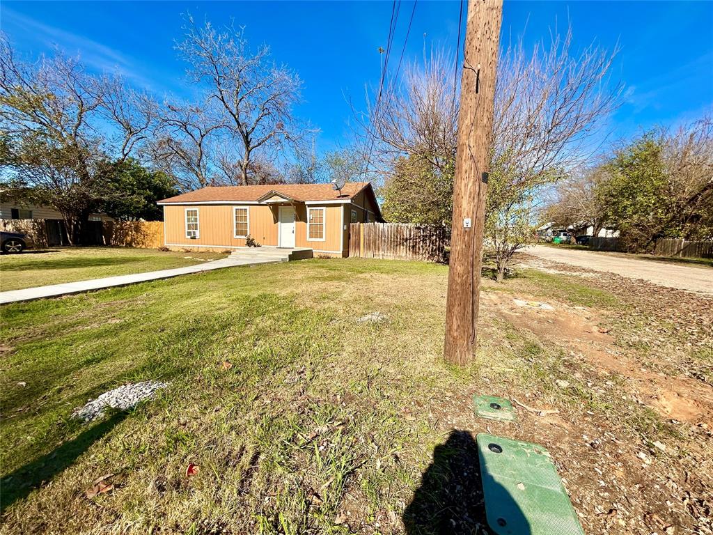 602 Ella Street Dublin, TX 76446 - Photo 13 of 13 a view of a yard in front of a house with a large tree