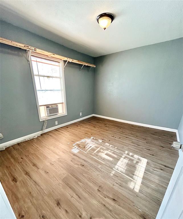 602 Ella Street Dublin, TX 76446 - Photo 2 of 13 an empty room with wooden floor and windows