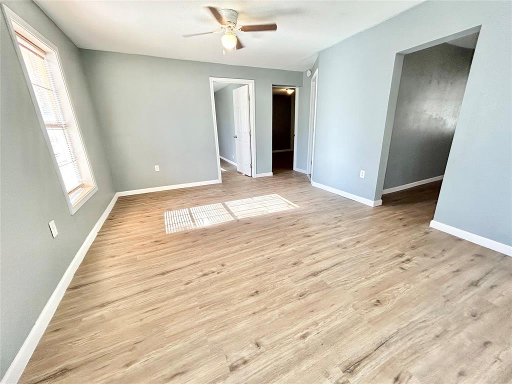 602 Ella Street Dublin, TX 76446 - Photo 9 of 13 a view of an empty room with wooden floor and a window