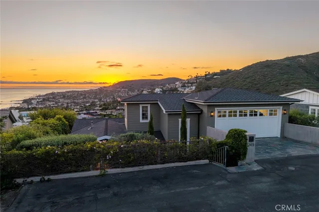 an aerial view of residential houses with outdoor space and ocean view