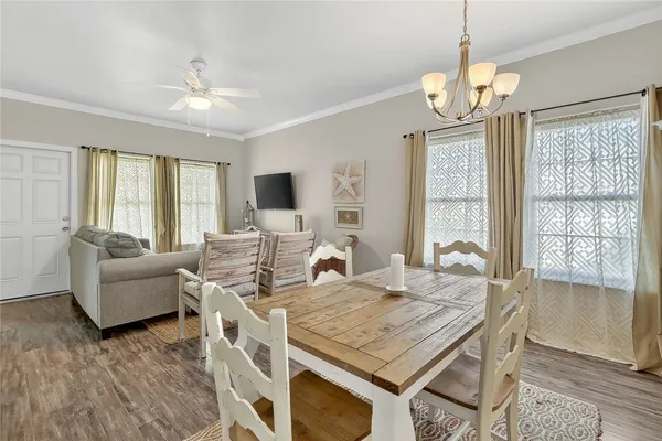 a view of a dining room with furniture a chandelier and wooden floor