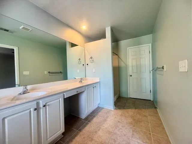 a bathroom with a granite countertop sink a toilet and shower
