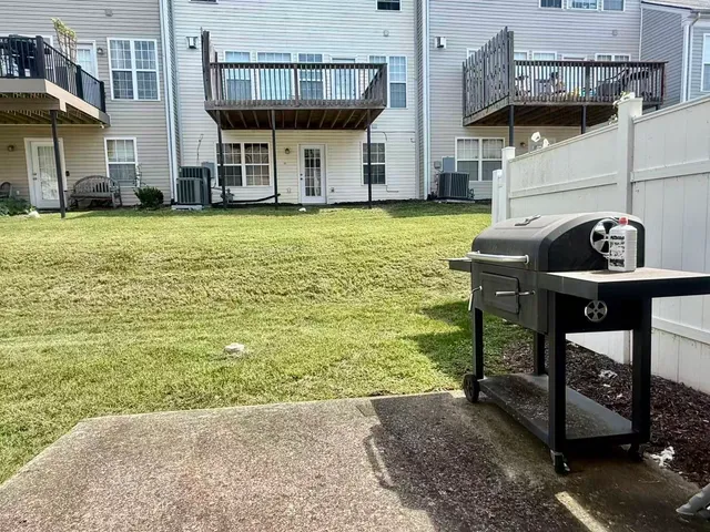 a view of a swimming pool with lawn chairs and a barbeque grill