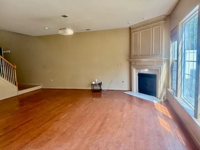a view of empty room with wooden floor and fireplace