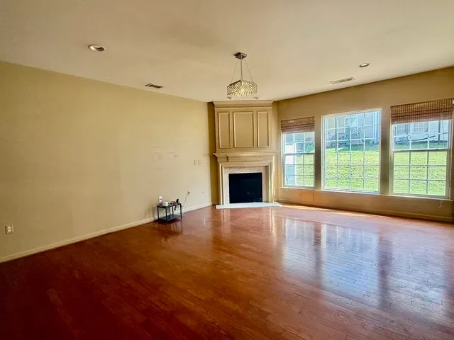 a view of an empty room with a fireplace and a window