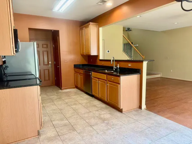 a kitchen with stainless steel appliances granite countertop a sink and a stove