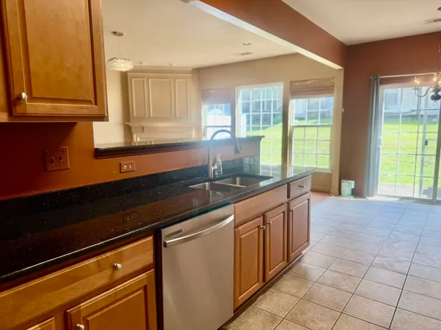 a large kitchen with granite countertop a sink and a stove