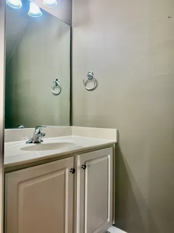 a utility room with a sink a mirror and vanity
