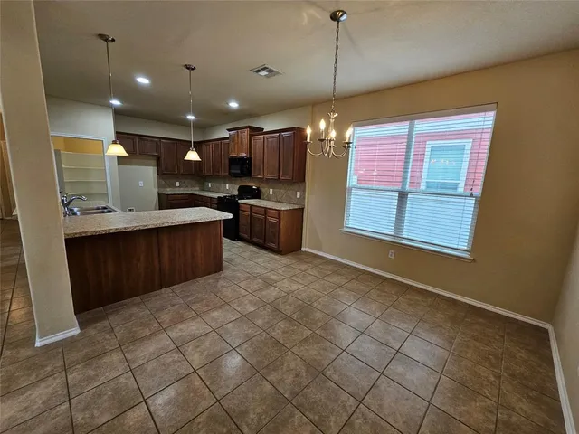 a large kitchen with a stove a sink dishwasher and a refrigerator