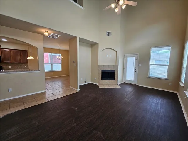 a view of a livingroom with wooden floor and a kitchen
