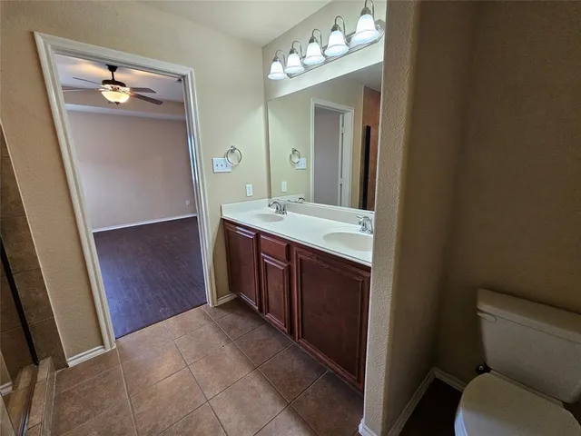 a en suite bathroom with a granite countertop sink and a mirror