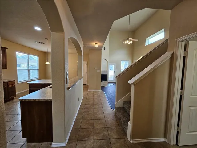 a hallway with entryway a sink and a mirror
