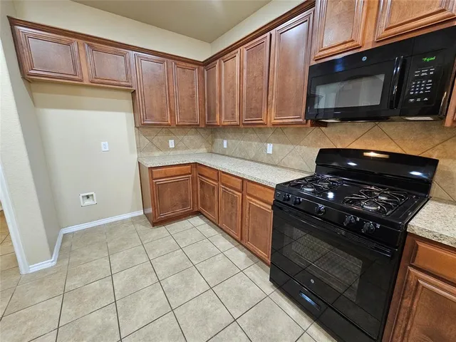 a kitchen with stainless steel appliances granite countertop a stove and a microwave