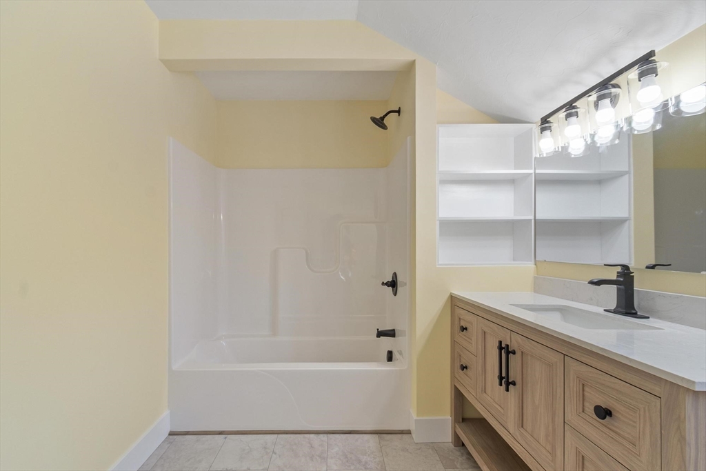120 Townsend Street, Unit 1 Pepperell, MA 01463 - Photo 12 of 25 a bathroom with a tub sink and a mirror