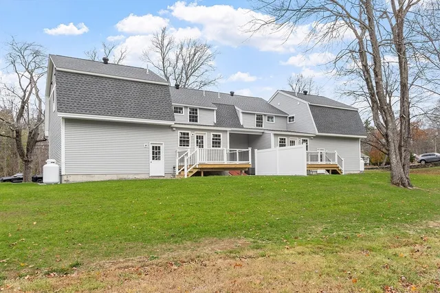 a view of a yard in front of a house with large trees