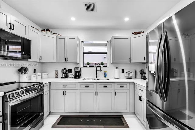 a kitchen with stainless steel appliances a stove a sink and cabinets