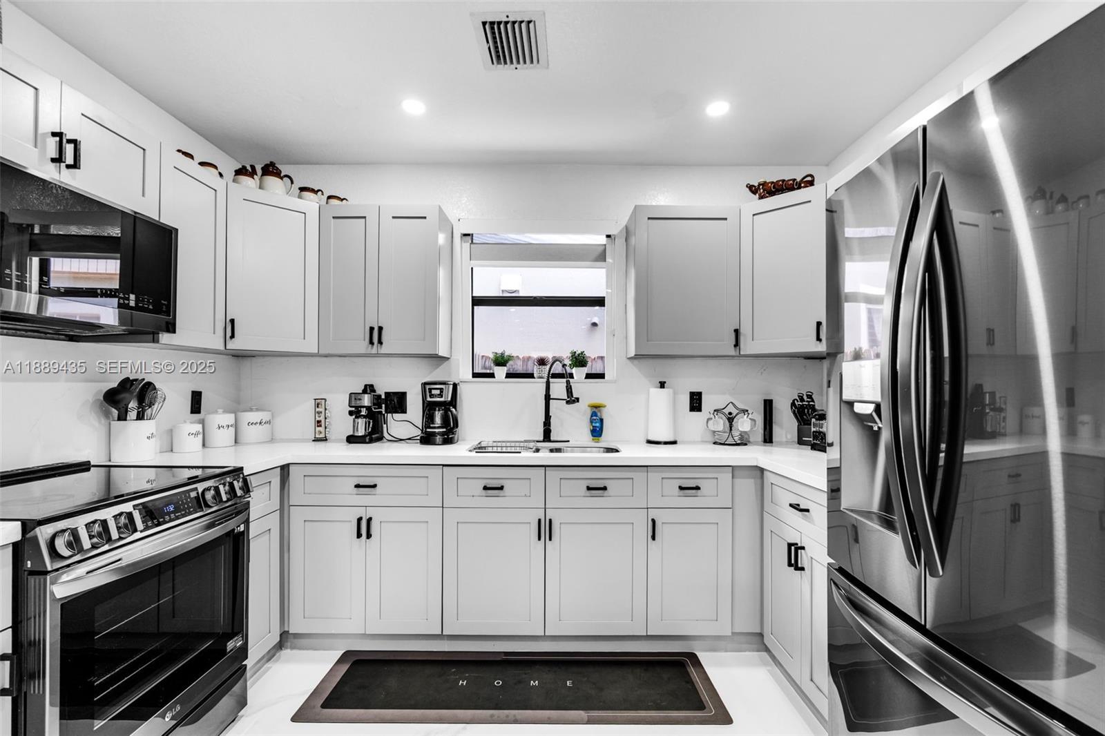 3022 Northwest 95th Street Miami, FL 33147 - Photo 11 of 47 a kitchen with stainless steel appliances a stove a sink and cabinets