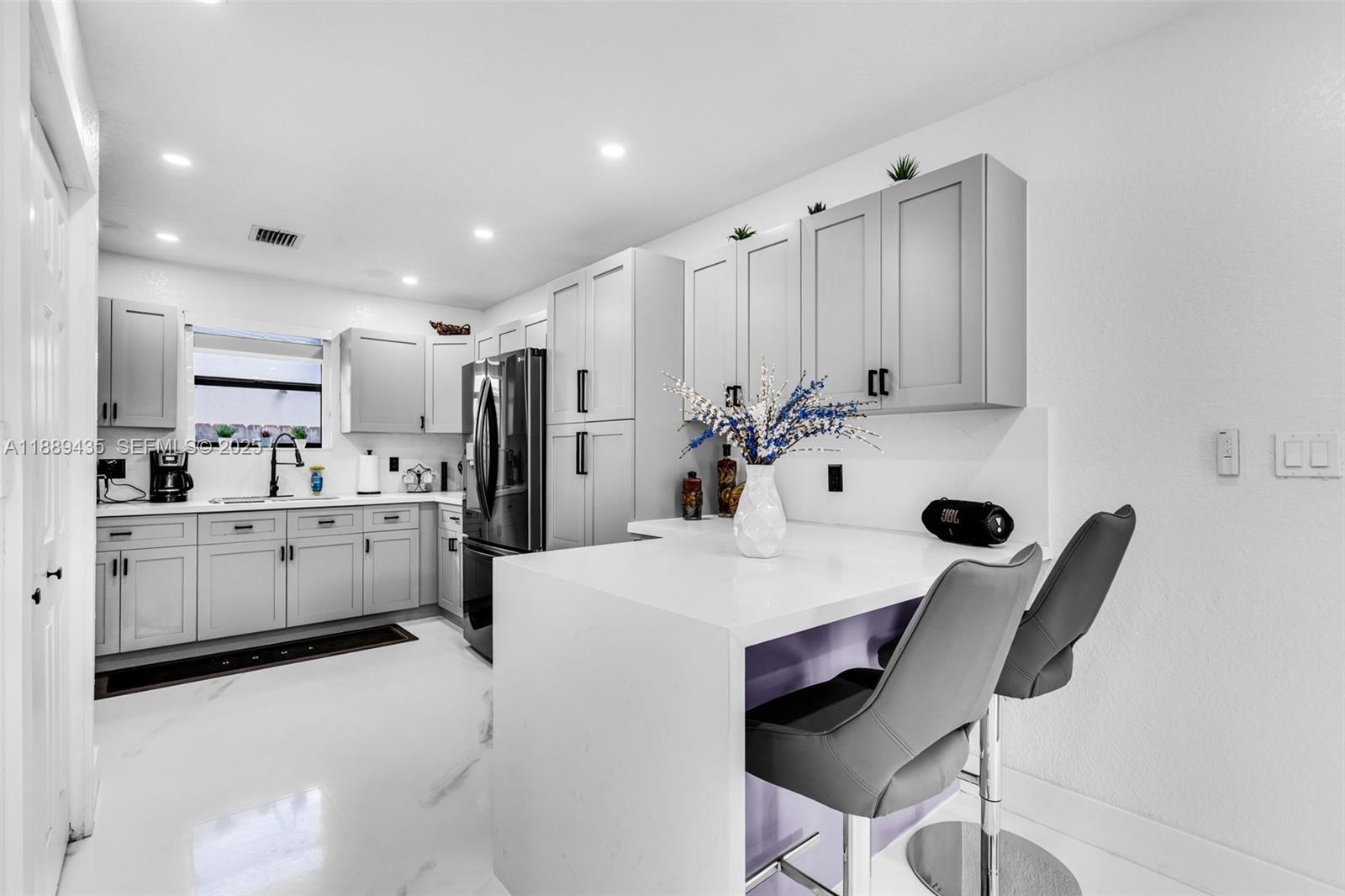 3022 Northwest 95th Street Miami, FL 33147 - Photo 13 of 47 a large white kitchen with white cabinets and stainless steel appliances